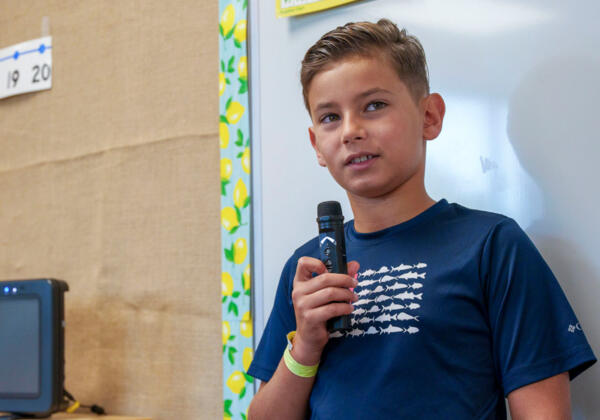 Student using wireless microphone in classroom for hearing augmentation